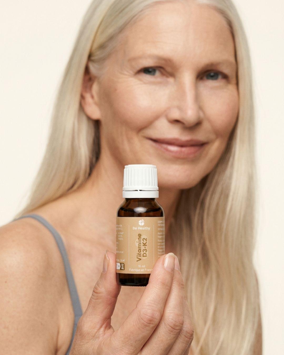 Femme tenant un flacon de Vitamine D3-K2