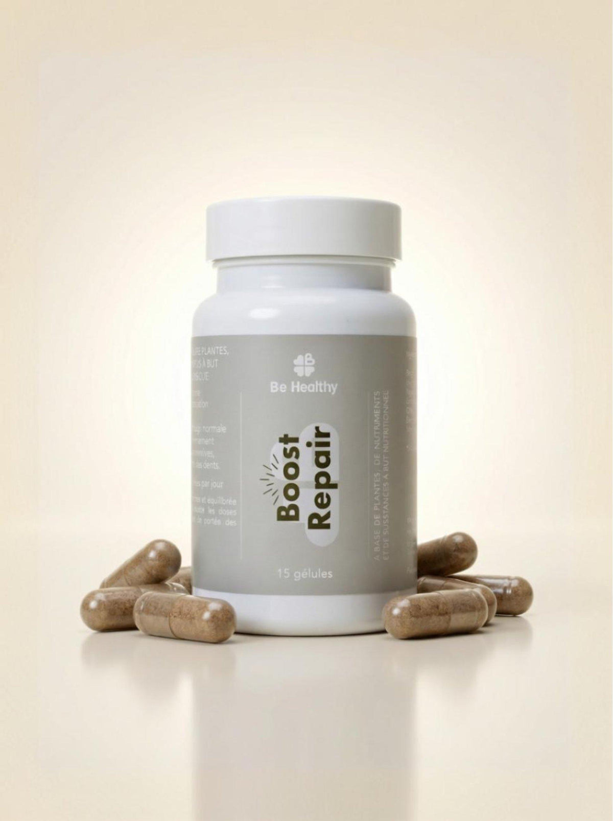 Flacon blanc à étiquette grise Boost Repair 15 gélules, entouré de gélules brunes posées sur fond beige Be Healthy